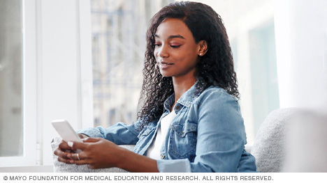 A woman connects with her care team by cell phone.